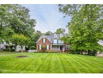 Charming brick two-story home featuring a well-manicured lawn, dormers, and a welcoming front porch at 244 Mantle Dr, Clayton, NC 27527