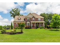 Beautiful two-story brick home with red shutters and a well-manicured lawn at 2912 Turning Brook Ln, Raleigh, NC 27616