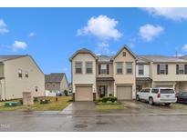 Charming townhome with two-car garage, landscaped front yard, and neutral exterior at 303 Leighann Ridge Ln, Rolesville, NC 27571