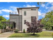 Modern two-story home featuring light siding, dark accents, a carport, and a rooftop patio at 304 S Tarboro St, Raleigh, NC 27610