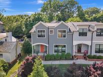 Inviting gray townhome featuring an orange front door, manicured landscaping, and a charming covered entryway at 511 Hamilton Cottage Way, Raleigh, NC 27605