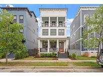 Stunning three-story home boasting double balconies, a charming front porch, and meticulous landscaping at 610 Velma Hopkins Ln, Raleigh, NC 27603