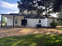 A nice rear exterior view of the home with white siding and dark trim at 65 Prospect Church Rd, Erwin, NC 28339