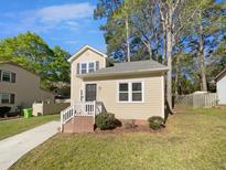 Charming two-story home with a well-maintained lawn, complemented by mature trees and a classic front porch at 720 Rawls Dr, Raleigh, NC 27610