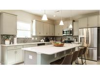 Bright kitchen features stainless steel appliances, large island with seating, and neutral color palette at 75 E American Marigold Dr # 37, Benson, NC 27504