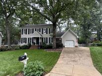 Charming two-story home with a well-manicured front lawn, mature trees, and a classic colonial design at 7517 Chippenham Ct, Raleigh, NC 27613