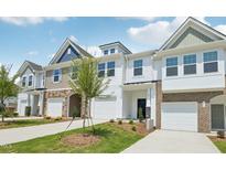 Charming townhomes featuring a mix of siding and stone accents, complemented by well-manicured lawns and private garages at 904 Kensley Grove Ln # 70, Fuquay Varina, NC 27526