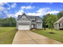 Charming gray two-story home featuring a well-manicured lawn and attached two-car garage at 1109 Agio Ct, Zebulon, NC 27597