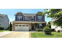 Charming two-story home with stone accents, attached two car garage, manicured lawn and complementary landscaping at 1116 Trotter Bluffs Dr, Holly Springs, NC 27540