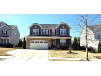 Charming two-story home features a stone accent garage and well-maintained lawn at 1116 Trotter Bluffs Dr, Holly Springs, NC 27540