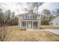 Inviting two-story home features a charming front porch and beautifully landscaped yard at 112 Ambergate Ct, Rocky Mount, NC 27804