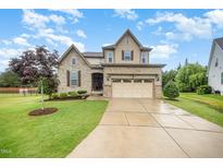 Charming two-story home with stone accents, landscaped yard, and a two car attached garage at 1201 Pleasant Falls Ct, Wake Forest, NC 27587