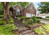Charming brick home with landscaped front yard and stone staircase leading to the entrance at 1224 Wedgeland Dr, Raleigh, NC 27615