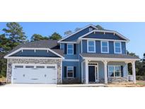 Charming two-story home with blue siding, stone accents, and a two-car garage at 131 River Chapel Dr, Fuquay Varina, NC 27526