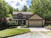 Charming two-story home with a landscaped front yard and attached two-car garage, surrounded by lush trees at 1514 John Jones Rd, Bahama, NC 27503
