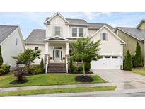 Charming two-story home featuring a manicured lawn, inviting entryway, and attached two-car garage at 204 Mill Chapel Rd, Chapel Hill, NC 27517