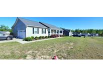Inviting home featuring a covered porch, attached garage, and a beautifully landscaped front yard at 212 Placid Pond Dr, Broadway, NC 27505