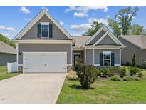 Charming home with a two-car garage, manicured lawn, and neutral gray siding under a sunny blue sky at 233 Theys Mill Way, Fuquay Varina, NC 27526