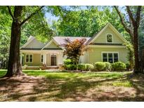 Charming home featuring a landscaped front yard, covered porch, and mature trees creating a peaceful setting at 2819 Ellis Chapel Rd, Bahama, NC 27503