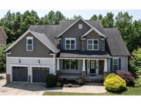 Charming two-story home featuring stone accents, a covered porch, and an attached two-car garage at 337 Shadowdale Ln, Rolesville, NC 27571