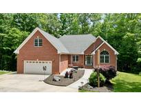 Charming brick home featuring an attached two-car garage and beautifully landscaped front yard at 3750 Mebane Rogers Rd, Mebane, NC 27302