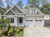 Charming home featuring a two-car garage, lush landscaping, and inviting front porch at 3914 Old Chapel Hill Rd, Durham, NC 27707