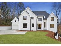 Stunning new construction home featuring a modern farmhouse design, lush lawn, and separate garage at 459 Windfall Creek Dr, Chapel Hill, NC 27517