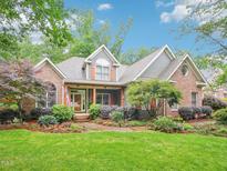 Charming brick home with a manicured lawn, mature trees, and inviting curb appeal at 5720 Brushy Meadows Dr, Fuquay Varina, NC 27526