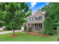 Charming two-story home featuring stone accents, a manicured lawn, and a welcoming front porch at 62 Jubilee Ct, Clayton, NC 27527