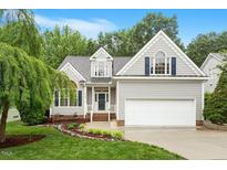 Charming home featuring a landscaped front yard, two-car garage, and a welcoming entrance at 6335 Cedar Waters Dr, Raleigh, NC 27607