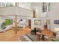 Spacious living room showcasing natural light, hardwood floors, open layout to the kitchen and unique architectural details at 6412 Heartwood Dr, Chapel Hill, NC 27516