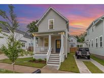 Charming home featuring a cozy front porch, manicured lawn, and a private driveway for easy parking at 902 B Oakland Ave, Durham, NC 27705