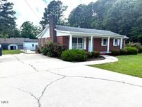 Charming brick home with a well-maintained front yard and a long driveway at 100 E Dale Dr, Oxford, NC 27565