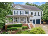 Charming two-story home with a welcoming front porch and beautifully landscaped front yard at 101 Ironcreek Pl, Apex, NC 27539