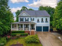 Charming two-story home with a well-manicured lawn, inviting front porch, and attached two-car garage at 101 Ironcreek Pl, Apex, NC 27539