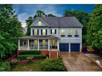 Charming two-story home features a covered front porch, brick accents, and a two-car garage at 101 Ironcreek Pl, Apex, NC 27539