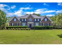 Beautiful brick home with a manicured lawn and lush landscaping at 107 Stargrass Ave, Clayton, NC 27527
