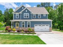 Charming two-story home boasts a manicured lawn and a classic blue exterior at 108 Wilson Farm Ln, Clayton, NC 27527