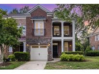 Charming brick townhouse showcasing a two-story facade, stone accents, and a quaint balcony at 109 Longchamp Ln, Cary, NC 27519