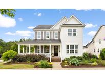Charming two-story home showcasing a well-manicured lawn and inviting front porch at 1205 Quincy Cottage Rd, Hillsborough, NC 27278