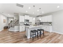 Modern kitchen featuring white cabinets, stainless steel appliances, and a center island with marble countertops at 1310 Compass Dr, Durham, NC 27713