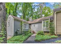 Charming exterior showcasing a home with a garden path and natural surroundings at 1702 Falls Church Rd, Raleigh, NC 27609