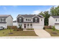 Charming two-story home with landscaped yard, black shutters, and attached two-car garage at 188 Karlov Rd, Garner, NC 27529