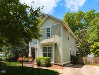 Charming two-story home with sage-colored siding, white trim, and a balcony, surrounded by mature trees and landscaping at 201 Cooke St, Raleigh, NC 27601