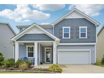 Charming two-story home with blue siding, white trim, covered porch, and attached two-car garage at 256 Summer Ranch Dr, Fuquay Varina, NC 27526