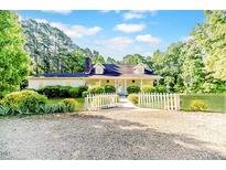 Charming single-story home with white picket fence and well-manicured landscaping creating a welcoming curb appeal at 2619 Steel Bridge Rd, Sanford, NC 27330