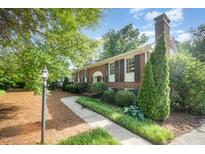 Charming brick home featuring manicured landscaping and walkway to the front door at 2800 Glen Burnie Dr, Raleigh, NC 27607