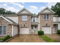 Charming townhome with stone accents, attached garage, and manicured lawn at 2822 Pickett Rd # 173, Durham, NC 27705