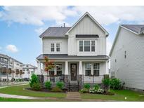Beautiful two-story home with a welcoming front porch, stone accents and manicured lawn at 2924 Watering Hole Way, Apex, NC 27502