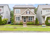 Charming two-story home with stone accents, inviting front porch, and well-maintained landscaping at 306 Crossland Dr, Chapel Hill, NC 27517
